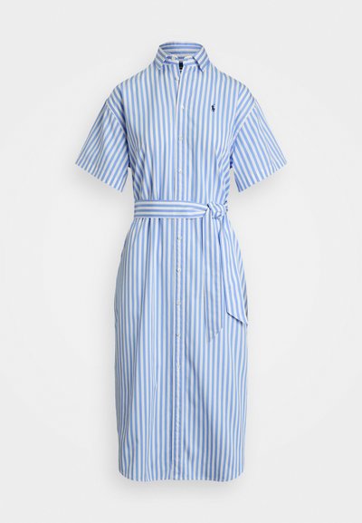 Vestido camisa com botões em azul e branco às riscas verticais, mangas curtas, com um cinto próprio e um logótipo no peito. Tecido de algodão.