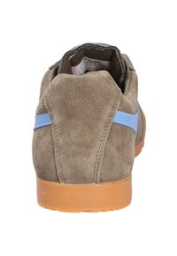 Sneaker in suede marrone con forma arrotondata, striscia di accento blu e suola in gomma beige. Texture morbida e colletto imbottito per il comfort.