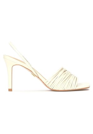 Beige Slingback-Schuh mit hochgezogener, dünner Absätze, der ein plissiertes Leder-Obermaterial und einen glatten Zehenriemen aufweist. Minimalistisches Design mit dezenten Akzenten.
