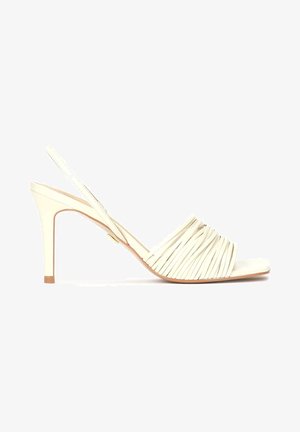 Beżowe buty na obcasie typu slingback z wysokim, cienkim obcasem, z plisowaną skórzaną cholewką i gładkim paskiem na palcach. Minimalistyczny design z subtelnymi akcentami.