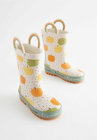 Bottes de pluie en caoutchouc blanches avec des motifs de citrouilles orange et vertes, des pois noirs, et une bande verte avec "P est pour citrouille" en blanc près de la semelle.