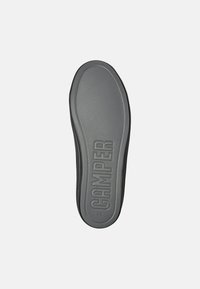Schwarze Gummisohle mit strukturiertem Oberflächen; mit dem eingeprägten Schriftzug "CAMPER"; flaches Design mit abgerundeten Kanten, Größe 38 gekennzeichnet.