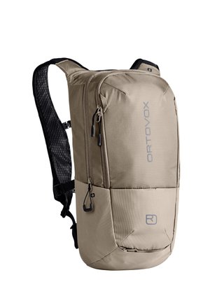 Kompakter beiger Rucksack mit gepolsterten schwarzen Schultergurten, mehreren Reißverschlussfächern und "ORTOVOX"-Schriftzug auf der Vorderseite.