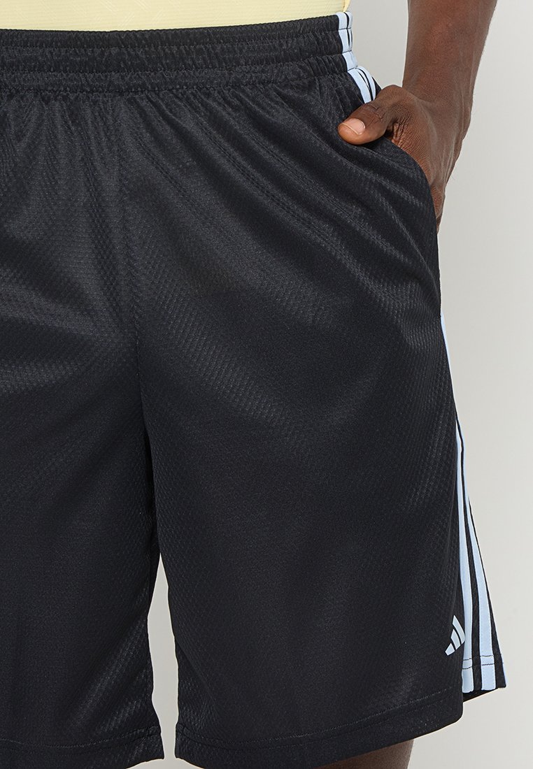 Pantalones cortos deportivos negros hechos de tejido transpirable, con una cinturilla elástica y franjas blancas en los laterales que presentan un logo cerca del dobladillo.