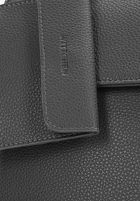 Portefeuille en cuir noir avec une surface texturée, des coutures contrastantes, une fermeture à rabat et un logo de marque en relief à l'avant.