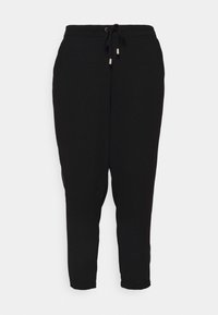 Zwarte joggingsbroeken van zachte stof, met een elastische tailleband en een trekkoord, en taps toelopende enkels.