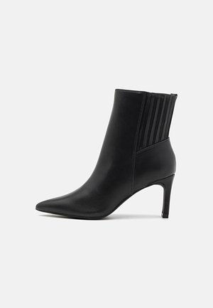 Bottes noires à la cheville avec un bout pointu, en cuir lisse, présentant des accents côtelés verticaux sur les côtés et un talon fin et haut.