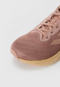Lichtroze sportshoe met een ademende bovenzijde van mesh, een ronde neus en een getextureerde tan rubberen zool. Voorzien van subtiele branding en vetersluiting.