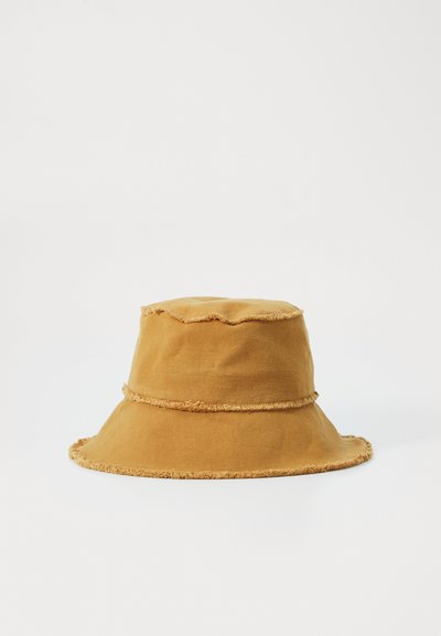 Chapeau seau en coton marron avec des bords effilochés, un large bord et une couronne arrondie. Design simple sans motifs ni éléments supplémentaires.