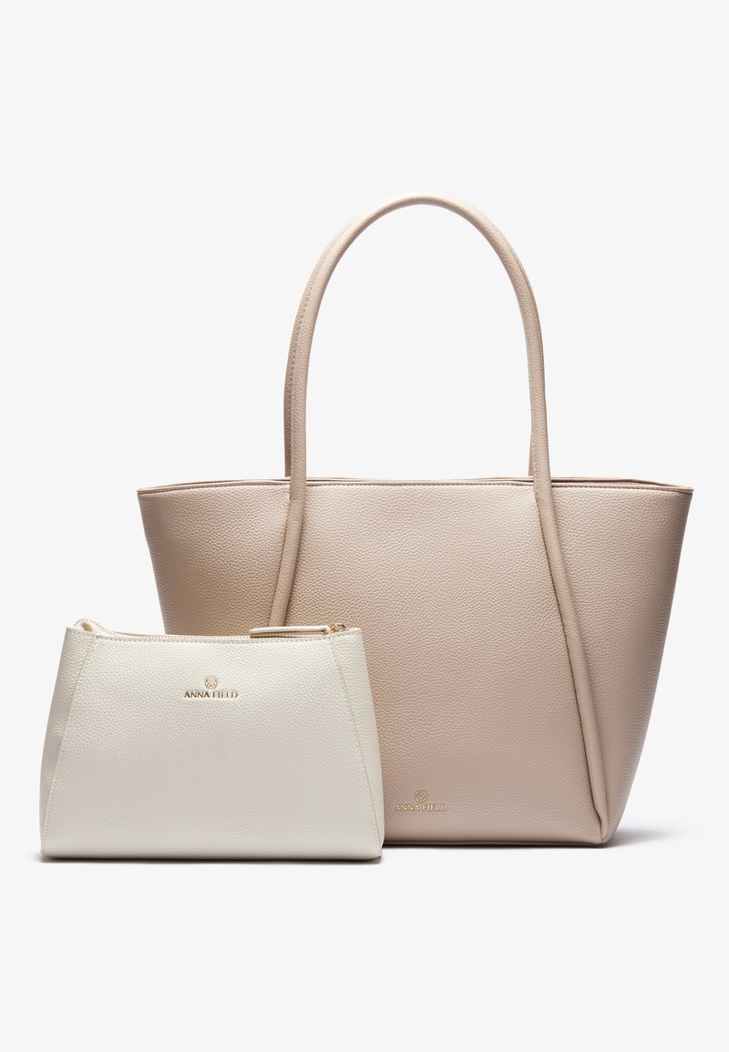 Μεγάλη μπεζ τσάντα ψάθας με υφή, που διαθέτει δύο μακριές λαβές. Συνοδεύεται από ένα μικρό λευκό φερμουάρ με λείο φινίρισμα.