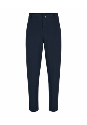 Mano dalla pelle scura posta nella tasca anteriore di pantaloni blu navy testurizzati con cintura in pelle marrone scuro.