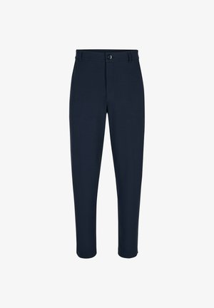 Mano dalla pelle scura posta nella tasca anteriore di pantaloni blu navy testurizzati con cintura in pelle marrone scuro.