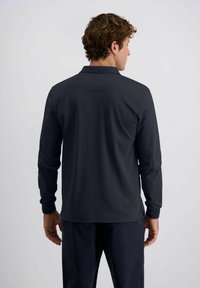 Langärmliges Poloshirt in dunkelblau, mit einem Kragen, strukturiertem Stoff und seitlichen Schlitzen. Die Rückansicht zeigt Details der Schulternaht.