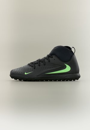Čierna vysoká športová obuv Nike s neónovo zelenými logami Swoosh a textúrovanou podrážkou, navrhnutá na používanie na vonkajšom trávniku.