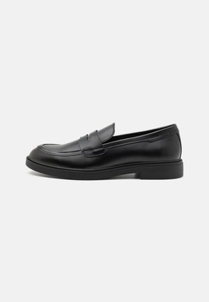 Zwarte leren loafers met een ronde neus, gestikte accenten en een lage rubberen zool. Glad textuur, minimalistisch ontwerp en instapstijl.