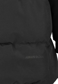 Black puffer jacket with a matte finish. Features a textured fabric and a logo embossed on the front. Includes knit accents on sleeves.