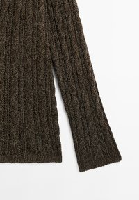 Manche et partie basse du torse d'un pull en maille torsadée marron foncé sur fond blanc, montrant un motif tricoté texturé et un ourlet côtelé.