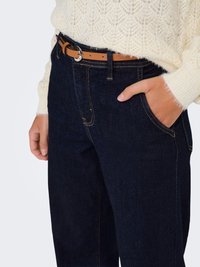 Jean denim foncé taille haute avec coutures renforcées, poches latérales et ceinture marron clair avec une boucle ronde en argent.