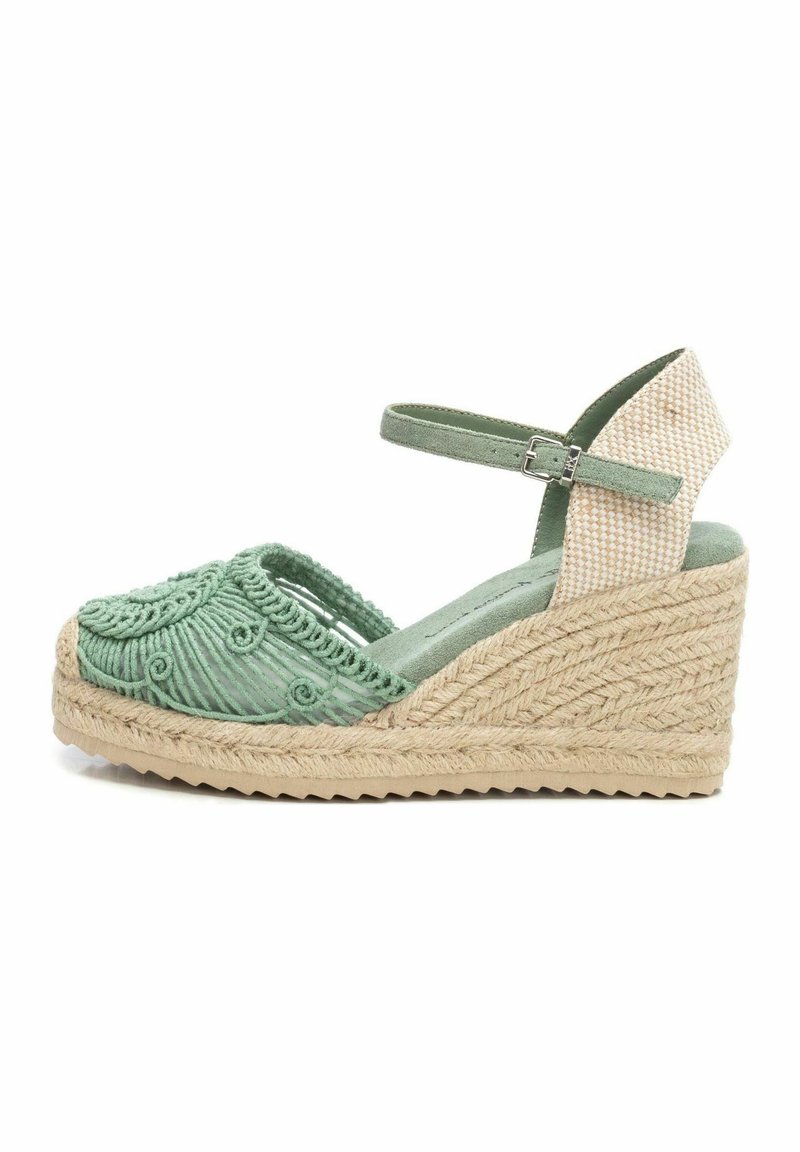 Sandalia de cuña de esparto verde bordada con suela de yute, que presenta una correa texturizada y diseño de punta abierta. Acentuada con un talón estampado.