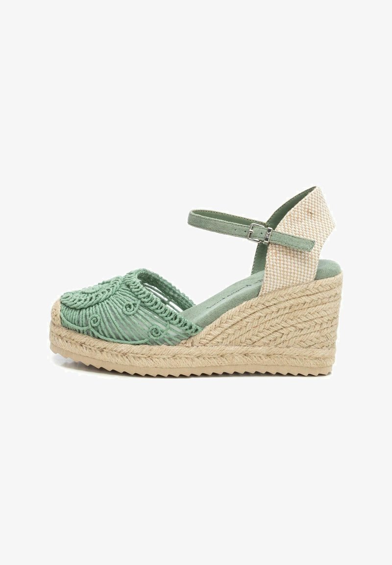 Sandalia de cuña de esparto verde bordada con suela de yute, que presenta una correa texturizada y diseño de punta abierta. Acentuada con un talón estampado.