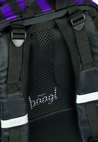 Zaino a rete nera con interno dal design traspirante, spallacci regolabili e un accento bianco con la scritta "baagl" ricamata in argento.