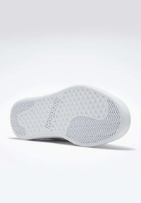 Semelle blanche de chaussure de sport avec une surface texturée, présentant un motif en diamant et une prise en caoutchouc. "Reebok" imprimé sur le côté de la semelle.