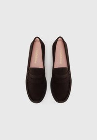 Mørkebrune semskede loafers med en glat overflade, rund tå og dekorativ syning foran. Lyserøde indlægssåler med logo-detalje.