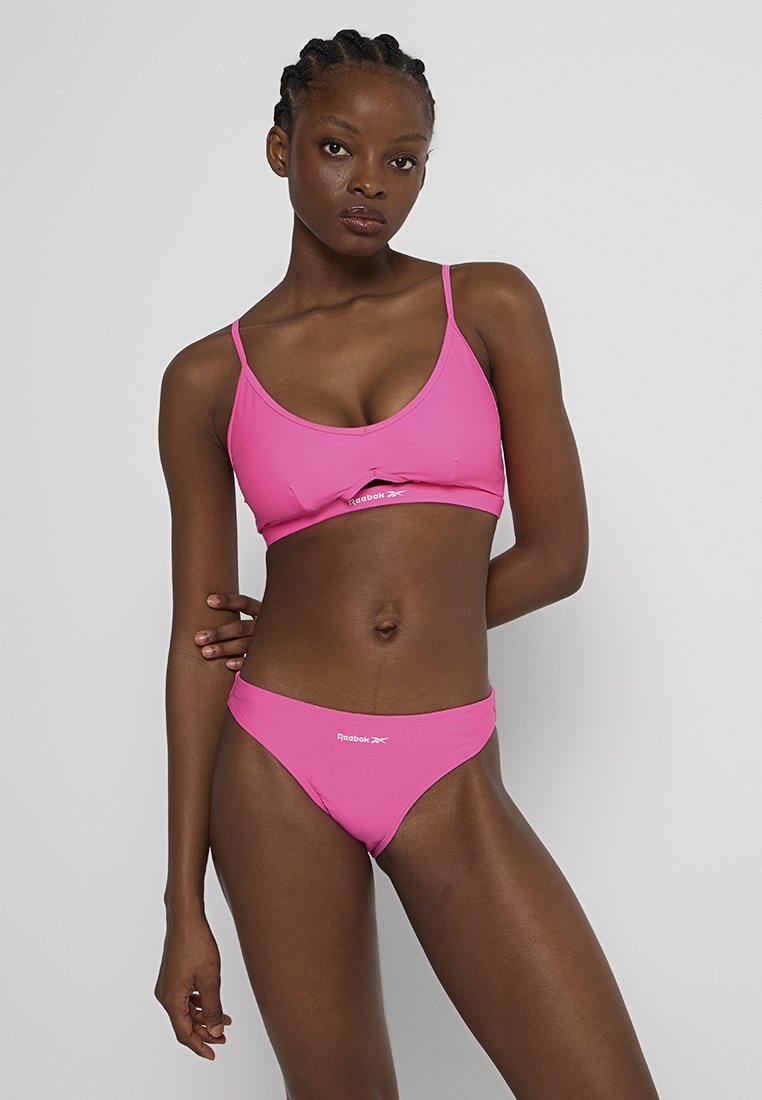 Rosa Bikini-Set mit einem Top mit Rundhalsausschnitt und passenden tief sitzenden Slips. Glattes synthetisches Material mit einem Reebok-Logo-Detail auf der Vorderseite.