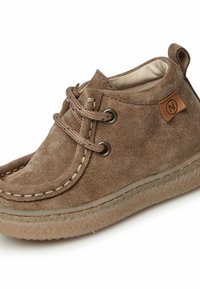 Stivaletto in suede marrone con dettagli cuciti, punta rotonda e suola in gomma testurizzata. Presenta occhielli rinforzati e un'etichetta in pelle brandizzata.
