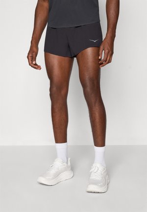 Black athletic shorts with a sleek design, featuring a subtle reflective logo on the front. Paired with white sneakers and socks.