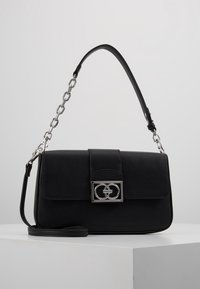 Black leather handbag with silver chain and clasp featuring interlocking circle design, displayed on white surface with gray background.