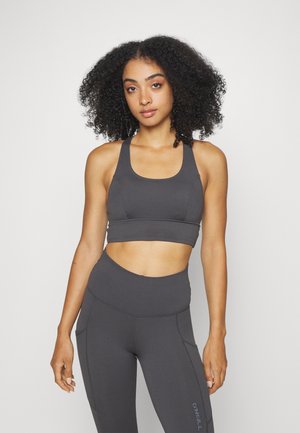 Σκούρο γκρι ριγέ αθλητικό σουτιέν με στρογγυλή λαιμόκοψη και αντίστοιχες ψηλόμεσες κολάν, με διακριτές ραφές και πλαϊνές τσέπες.