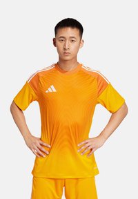 Helles orange Fußballtrikot mit einem graduellen Design und strukturierten Linien, weißem Adidas-Logo und kontrastierenden helleren Ärmeln.