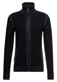 Stickad zip-up tröja i svart med ribbat mönster. Har hög krage, två sidofickor och kontrasterande mörkblå detaljer längs ärmarna.