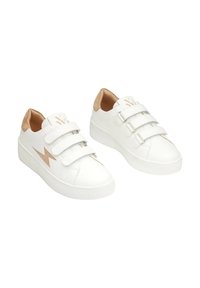 Baskets en cuir blanc avec trois bandes Velcro, un accent en daim beige au talon et une semelle en caoutchouc blanc texturé avec un motif en zigzag.