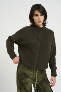 Dark green knit cardigan with a high collar, black buttons, and relaxed fit; worn over tie-dye olive green cargo pants featuring pockets.