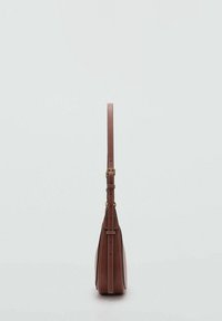 Bolso de piel marrón con un perfil delgado, correa ajustable, detalles en dorado y costuras en blanco contrastante. Base plana para estabilidad.