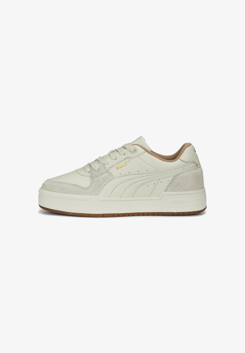 Vit sneaker med en slät läderövre och texturerade mockadetaljer. Funktioner inkluderar en beige häl, snörning och gummisulor. Guldbranding.