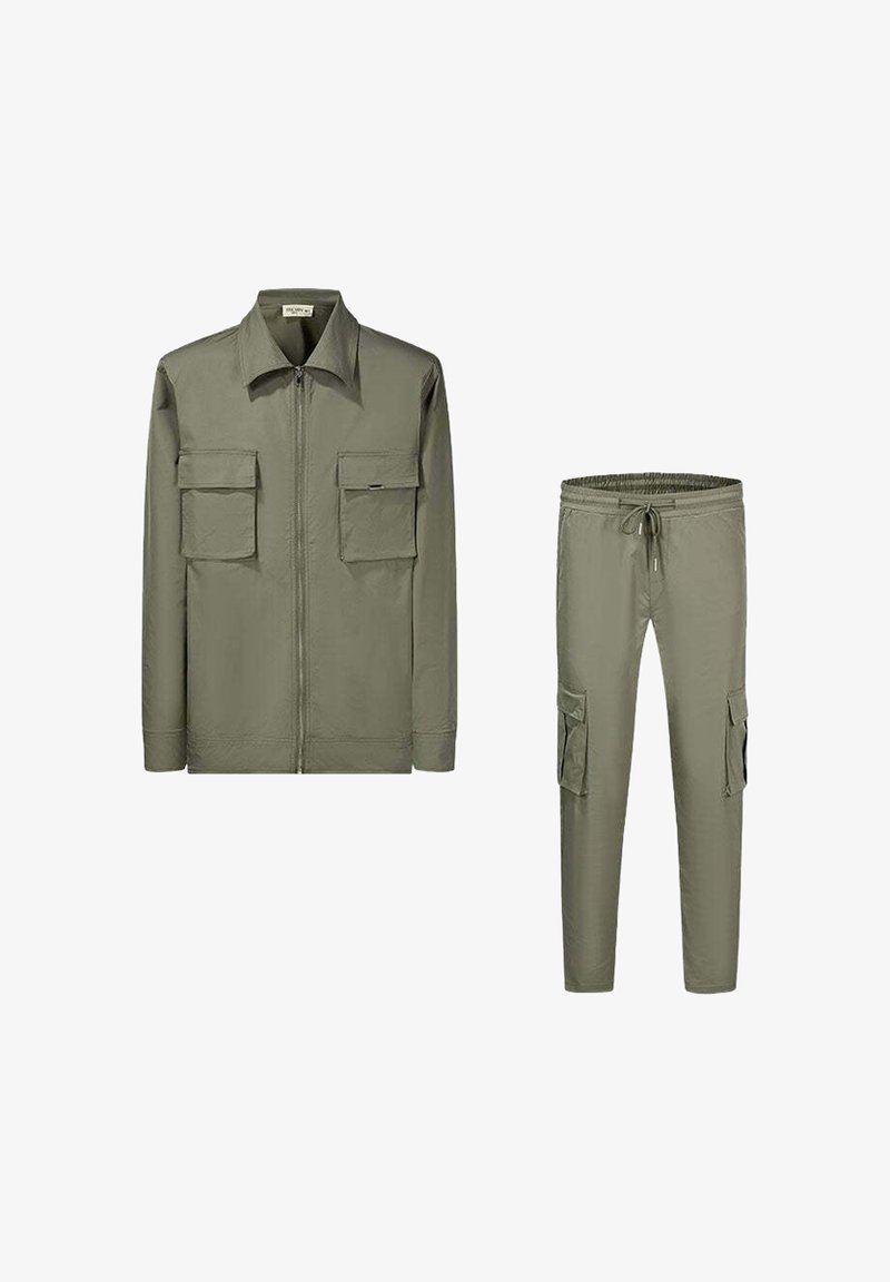 Veste en coton vert olive avec une fermeture éclair à l'avant, un col pointu et deux poches poitrine. Pantalons cargo assortis en vert olive avec des poches latérales et une taille élastique.