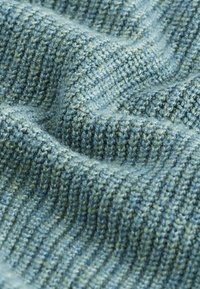 Material tricotat texturat în nuanțe variate de albastru și verde, având un model cu nervuri și o textură moale și pufoasă.