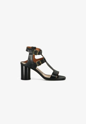 Sandales à talons en cuir noir avec bout ouvert, design T-strap et deux accents de boucles réglables à la cheville et au milieu du pied.