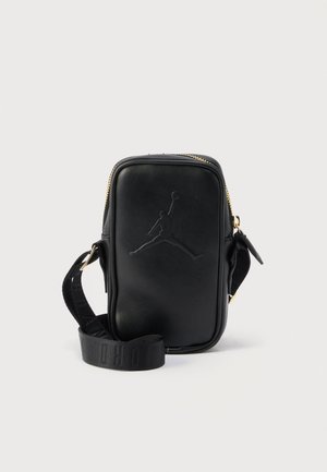 Sort rektangulær crossbody-taske med præget basketballspiller-logo, guldfarvet lynlås og justerbar bred stofrem på lys baggrund.