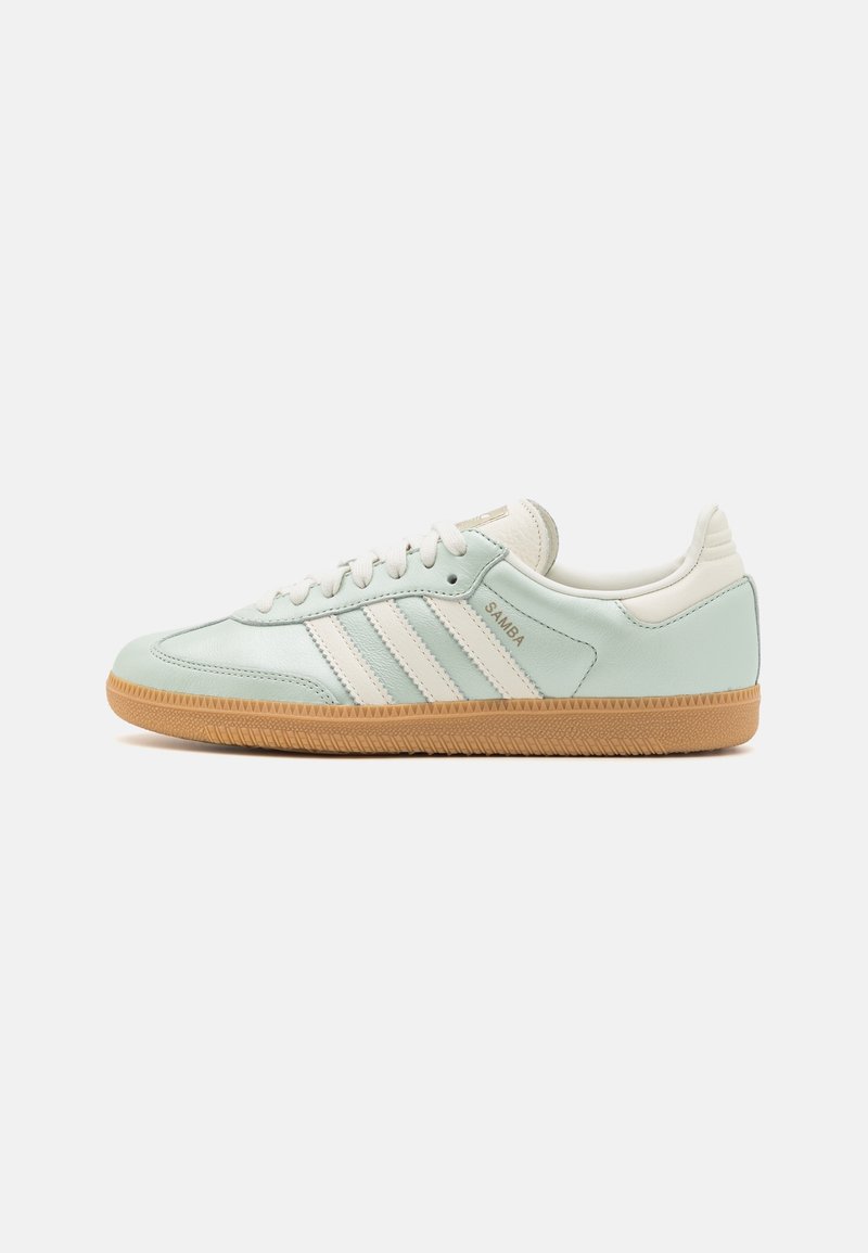 Baskets Adidas Samba bleu clair avec rayures blanches et semelle en gomme, présentées en vue de côté sur un fond uni.