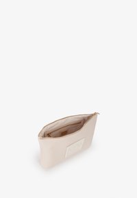 Bolso de cuero rosa claro con textura suave, cierre de cremallera y un bolsillo interior. Presenta un parche de marca en la parte frontal.