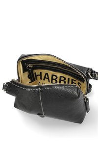 Borsa in pelle nera con finitura texturizzata, compartimenti con zip, fodera beige e cuciture bianche a contrasto. Logo visibile all'interno.