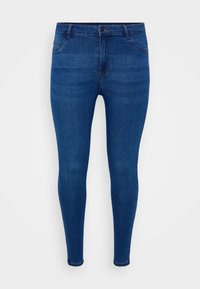 Jeans ajustados de mezclilla azul oscuro. Presentan una cremallera, diseño de cinco bolsillos y un sutil desvanecimiento. Textura suave con un ligero estiramiento.