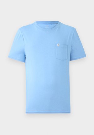 Camiseta de manga corta azul claro hecha de algodón suave. Presenta un escote redondo y un bolsillo en el pecho con una etiqueta de marca. Textura suave.