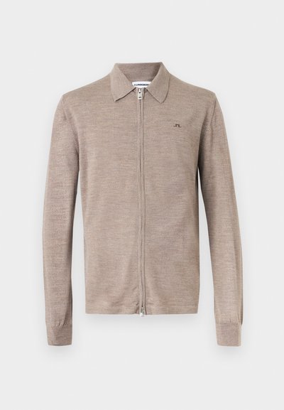 Μπεζ μάλλινο πουλόβερ με φερμουάρ, μακριά μανίκια, γιακά και μικρό λογότυπο JL στο αριστερό στήθος, απεικονίζεται σε απλό φόντο.