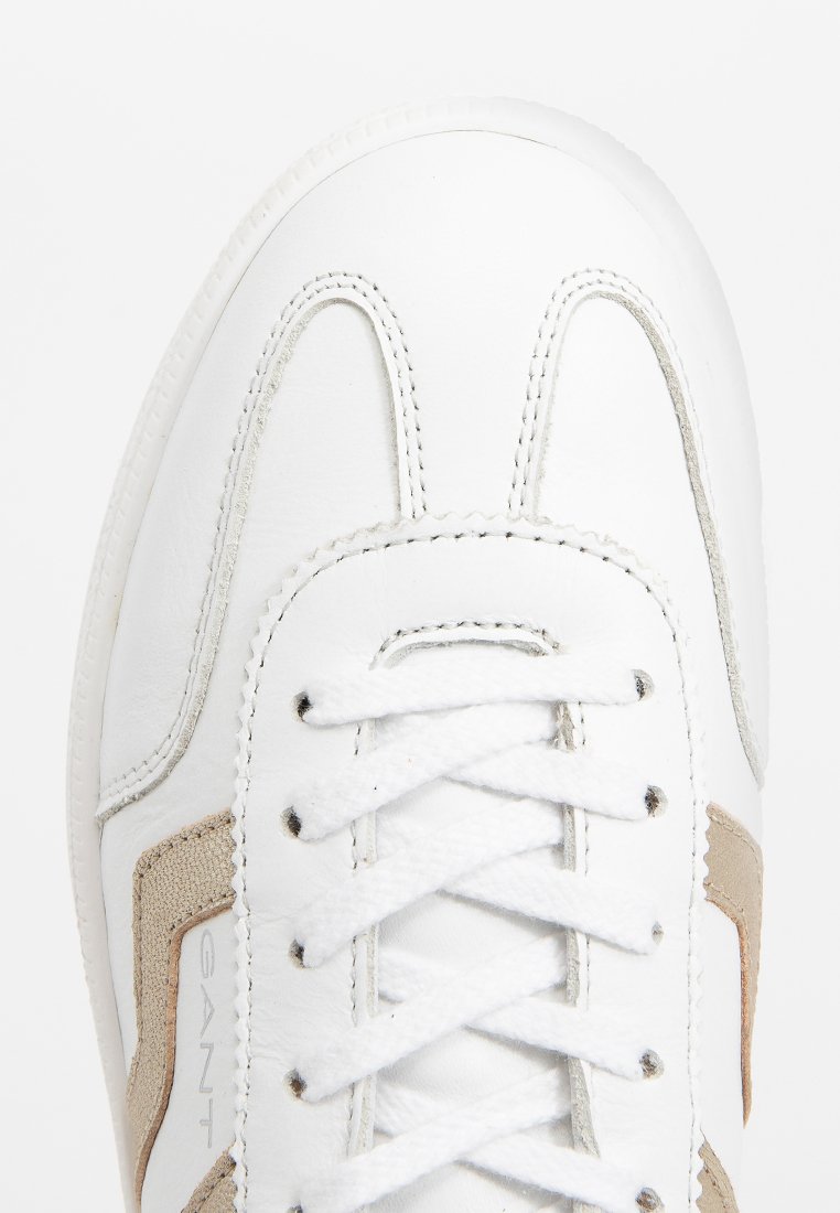 Białe skórzane sneakersy z beżowymi akcentami, zdobione teksturowanym przeszyciem, okrągłym noskiem i płaskimi białymi sznurówkami. Gładkie wykończenie z detalem logo.