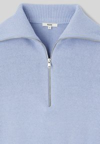 Pull en maille bleu clair avec un col montant zippé, présentant une texture côtelée et une étiquette portant "B2B" et la taille "S".